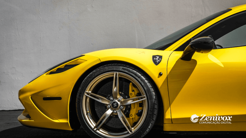 Imagem de um carro esportivo amarelo, com foco no design elegante da lateral dianteira, destacando a roda dourada e o logotipo da marca no para-lama. O fundo neutro em tom claro realça o contraste vibrante do veículo. Simbolizando o marketing de segmentação da Ferrari. No canto inferior direito, está presente o logotipo da Zenivox Comunicação Digital.