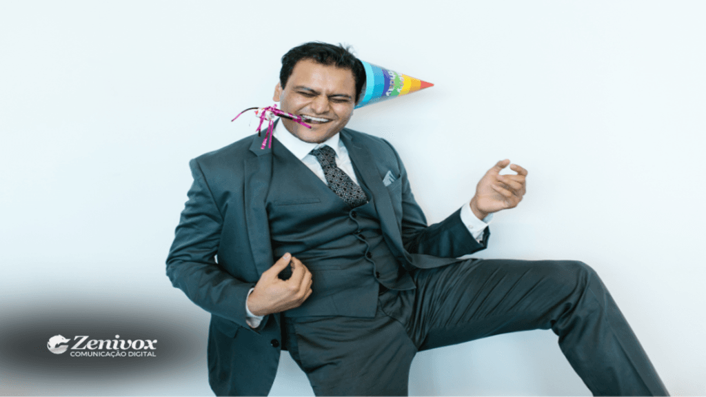 Homem de cinza terno escuro com chapéu de festa e um apito decorativo na boca, expressando alegria e energia, simbolizando o impacto de manter o bom humor para o sucesso nas vendas.