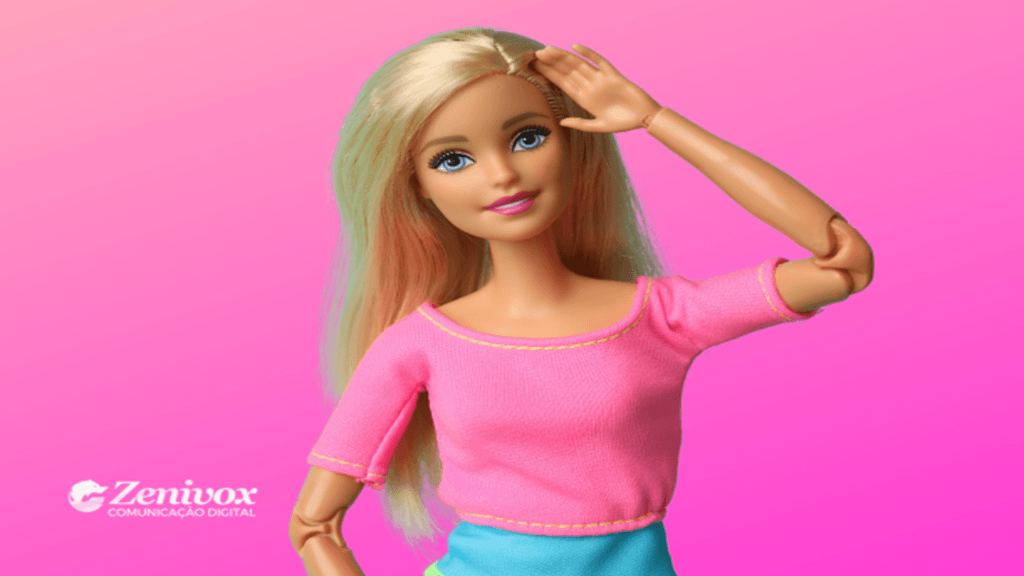 Imagem de uma boneca com cabelo loiro, usando roupas coloridas em tons de rosa e azul, sorrindo e posando em frente a um fundo rosa degradê, transmitindo a sensação do empreendedorismo criativo.