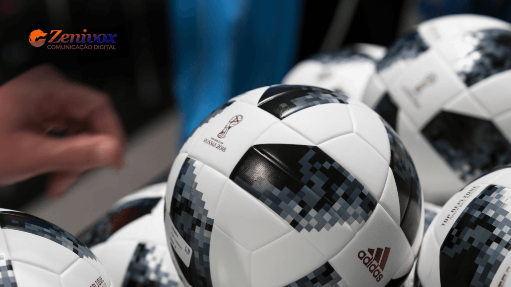 Bolas de futebol Adidas oficiais da Copa do Mundo FIFA 2018 em destaque. A marca Adidas e o logotipo do torneio são visíveis, reforçando a ideia de vantagem competitiva com parceria de sucesso da empresa no cenário esportivo global.