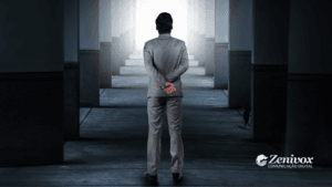 Homem de terno cinza visto de costas, caminhando por um corredor simétrico com iluminação ao fundo, representando a jornada estratégica e desafios do Gerente de Vendas. A imagem transmite profissionalismo, tomada de decisão e busca por resultados extraordinários.