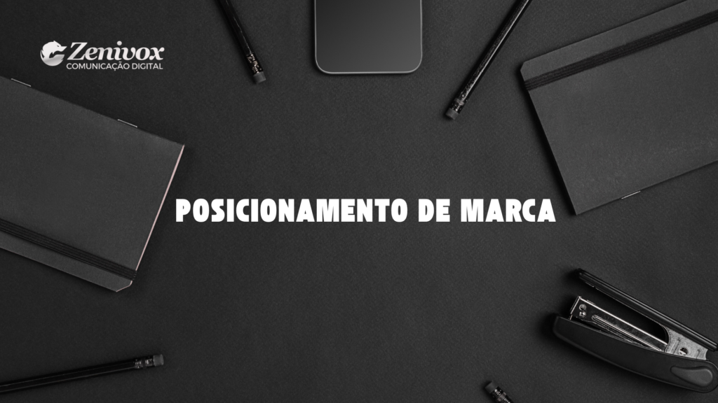 Fundo escuro minimalista com cadernos, lápis, grampeador e um smartphone organizados ao redor da frase central "Posicionamento de Marca". No canto superior esquerdo, o logotipo da Zenivox Comunicação Digital reforça a identidade visual.