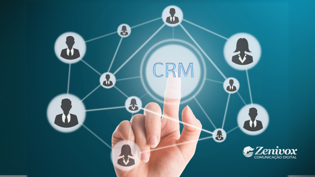 Uma mão aponta para o termo "CRM" em uma interface digital interativa, com ícones de pessoas conectadas em rede, simbolizando o gerenciamento de relacionamentos com clientes. O logo da Zenivox Comunicação Digital aparece no canto inferior direito.