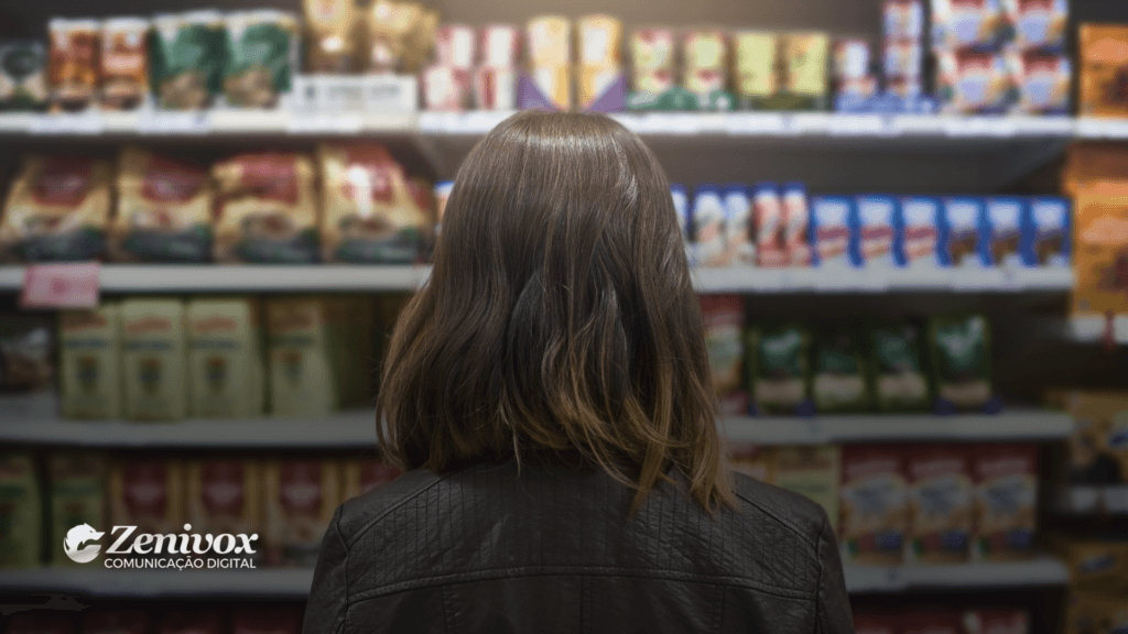 A imagem apresenta uma pessoa vista de costas, observando uma prateleira cheia de produtos em um supermercado. A diversidade de embalagens e cores destaca a importância de um design visual marcante. Essa cena simboliza como um bom modelo de logotipo é essencial para que uma marca se destaque em meio a diversas opções.