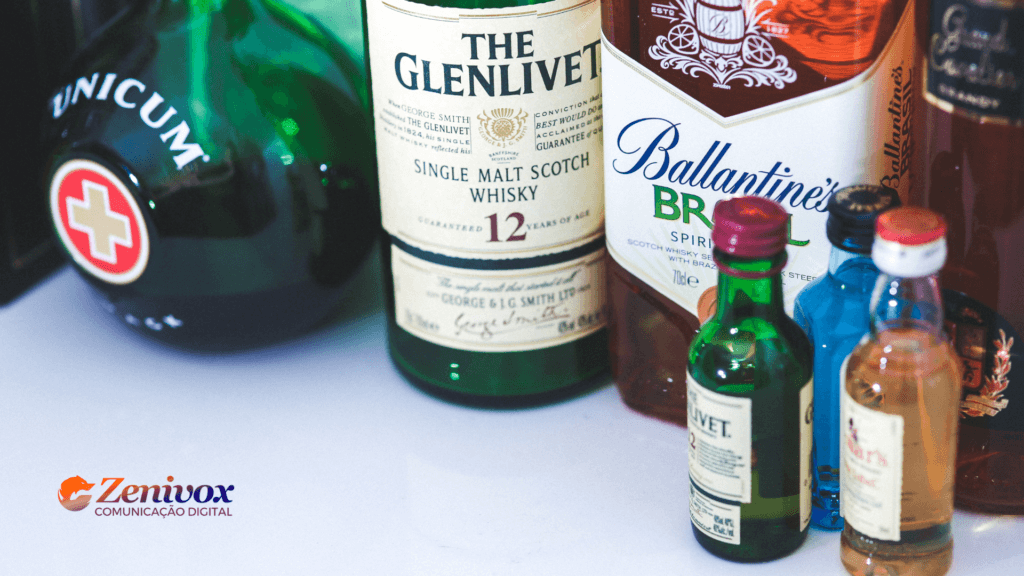 Portfólio de Produtos: Para Não Ficar na Ressaca do Mercado Misture como a Pernod Ricard: Um bom portfólio de produtos é a receita para o sucesso! Imagem com diversas garrafas de bebidas renomadas, incluindo The Glenlivet, Ballantine's Brasil e Unicum, destacando a variedade e qualidade que simbolizam um portfólio bem estruturado. A marca Zenivox aparece no canto inferior esquerdo, reforçando a ideia de comunicação digital e marketing estratégico para expandir seu leque de produtos e alcançar melhores resultados no mercado.