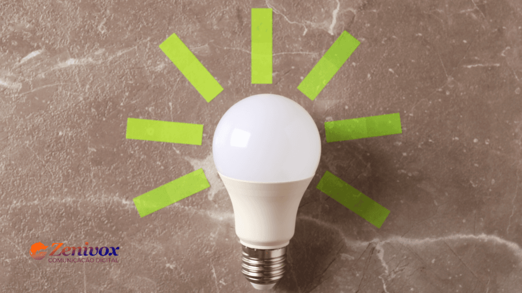 Imagem de uma lâmpada LED branca sobre uma superfície de pedra, com tiras de fita adesiva verde formando raios ao redor da lâmpada, simbolizando uma ideia sustentável. O logotipo da Zenivox Comunicação Digital está localizado no canto inferior esquerdo, destacando a conexão com práticas ecológicas e inovadoras e do marketing verde.