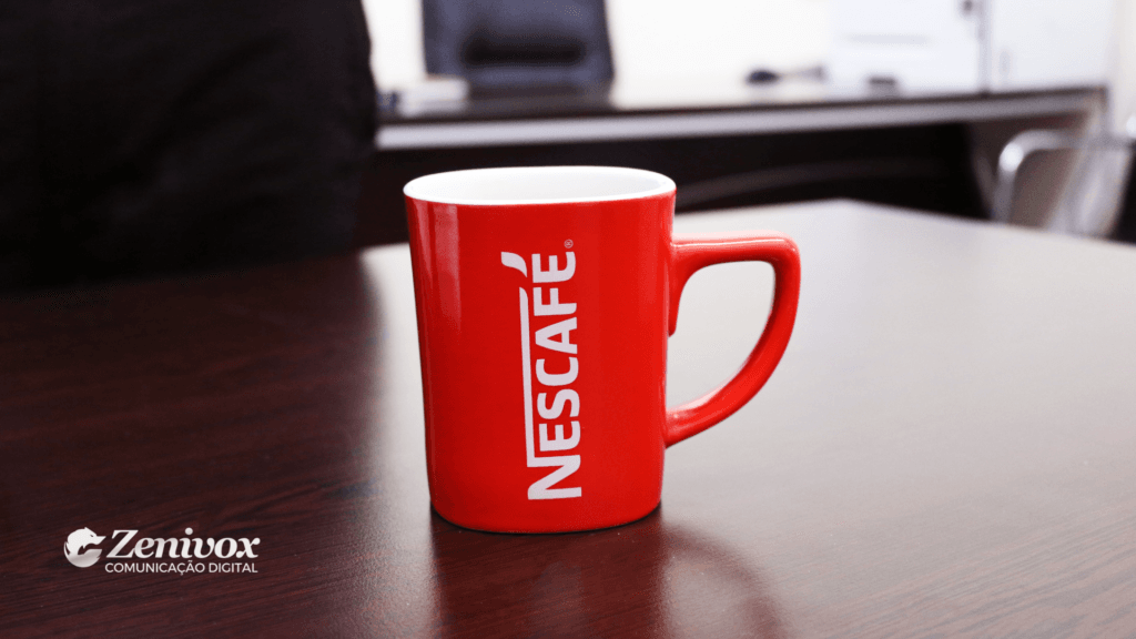 Caneca vermelha da Nescafé sobre mesa de escritório, simbolizando a estratégia de precificação e posicionamento de marca da Nestlé.