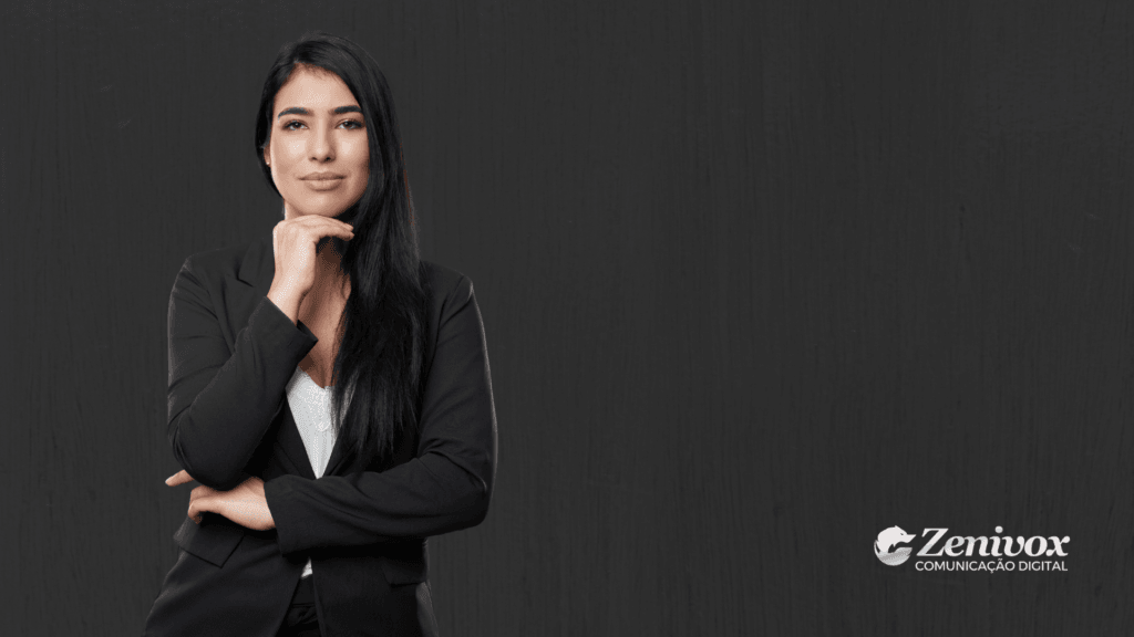 Mulher confiante em traje formal com expressão serena e postura firme, olhando diretamente para a câmera com a mão apoiada no queixo. O fundo escuro e o visual sóbrio reforçam a ideia de autoridade, reflexão e posicionamento. Logotipo da Zenivox no canto inferior direito.