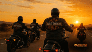 Quatro motociclistas vestindo jaquetas com o logotipo da Harley-Davidson pilotam juntos ao pôr do sol em uma estrada deserta. A imagem transmite liberdade, irmandade e pertencimento à marca, que é o segreda identidade de marca forte da Harley.