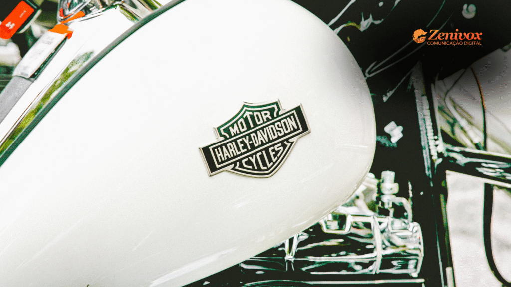 Close no tanque branco de uma moto Harley-Davidson com o logotipo clássico da marca em destaque. O design limpo e a tipografia robusta transmitem a estética forte e icônica da identidade visual da Harley.