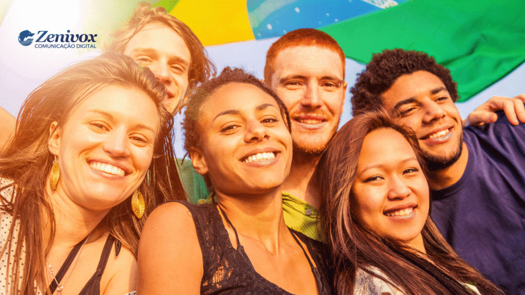 Imagem vibrante com seis jovens sorrindo juntos sob uma bandeira do Brasil ao fundo. Eles representam o Drible no Tarifaço Trump contra o Brasil. A luz do sol ilumina seus rostos com calor, criando um clima de esperança e atitude positiva. No canto superior esquerdo está o logotipo da Zenivox Comunicação Digital.
