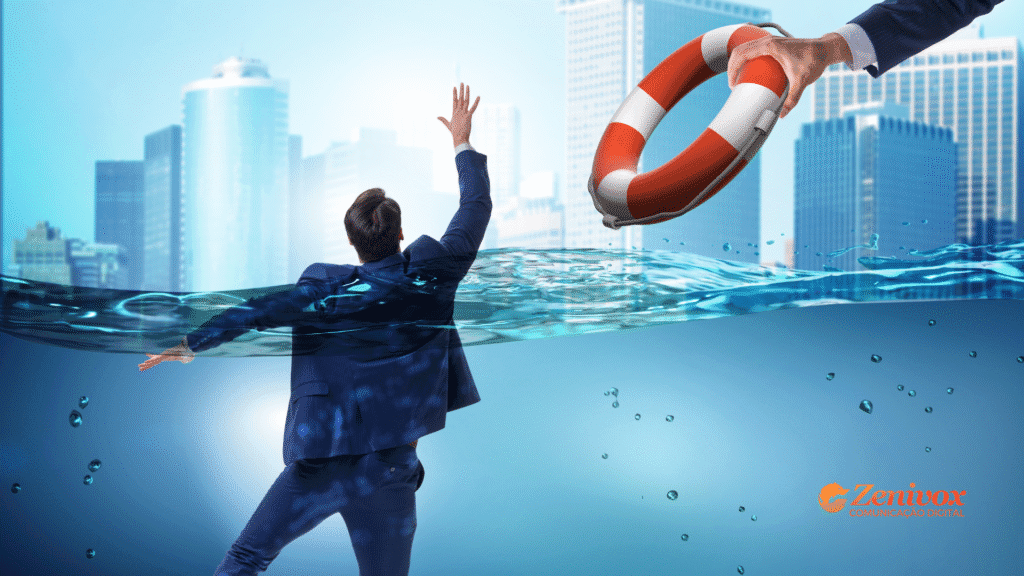 Empresário de terno parcialmente submerso na água em meio a uma cidade, levantando o braço para alcançar uma boia salva-vidas que está sendo estendida por outra mão. A imagem simboliza a importância do gerenciamento de riscos como ferramenta de salvação em meio a crises externas. Logotipo da Zenivox Comunicação Digital aparece no canto inferior direito.