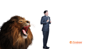 Homem de terno com expressão de medo encara um leão que ruge ferozmente ao seu lado esquerdo. A imagem representa os desafios imprevisíveis enfrentados por empreendedores, como o aumento do IOF e o tarifaço. No canto inferior direito, aparece o logo da Zenivox Comunicação Digital, sugerindo que o gerenciamento de riscos é essencial para sobreviver no ambiente de negócios hostil.