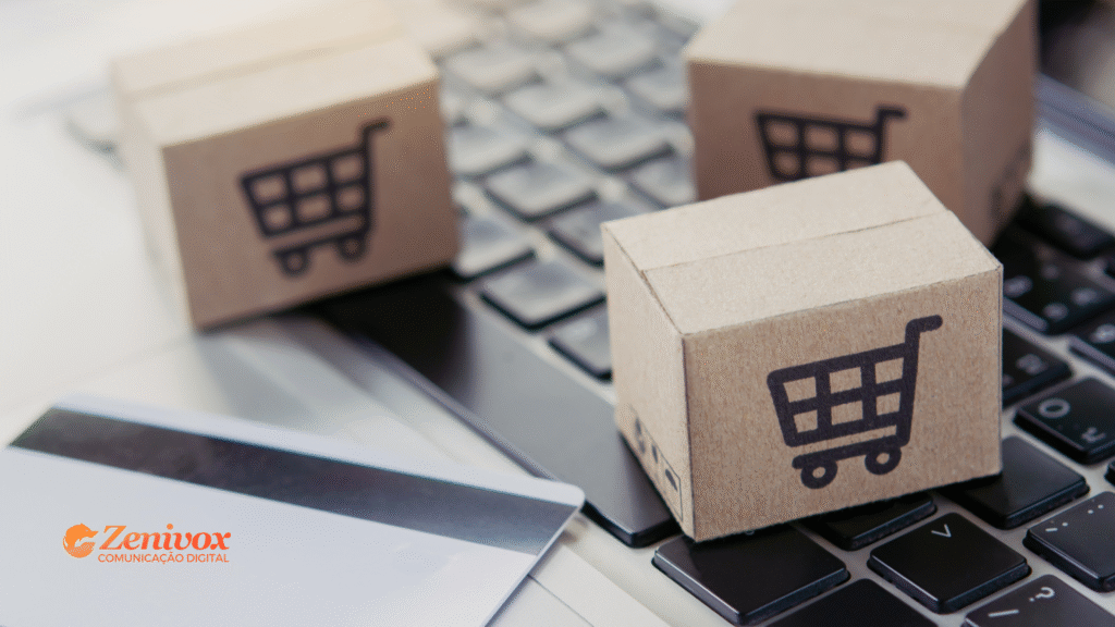 Três pequenas caixas de papelão com ícone de carrinho de compras estão sobre um teclado de notebook, simbolizando o comércio eletrônico e como vender na internet. Uma maquininha de cartão e um cartão de crédito aparecem em segundo plano. No canto inferior esquerdo está o logotipo da Zenivox Comunicação Digital.