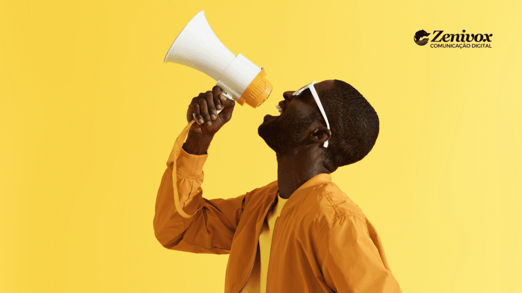 Homem negro estiloso usando jaqueta laranja e óculos brancos grita com entusiasmo em um megafone amarelo sobre fundo monocromático amarelo, simbolizando comunicação poderosa e carisma — atributos essenciais para um garoto propaganda de impacto.