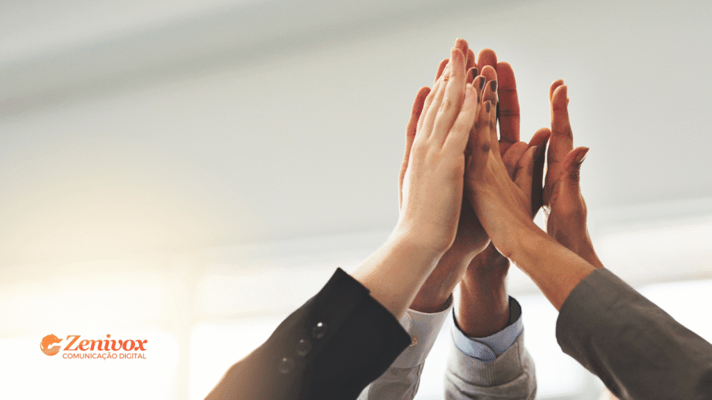 Mãos de diferentes pessoas se unindo em um gesto de high five, simbolizando trabalho em equipe e sucesso empresarial da gestão de negócios.