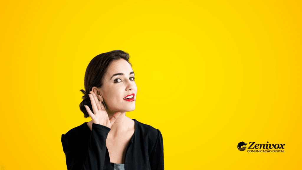 Mulher com expressão atenta e curiosa, inclinada levemente para frente e com a mão próxima ao ouvido em gesto de escuta. O fundo amarelo vibrante reforça a ideia de energia, foco e receptividade — simbolizando o ato da escuta ativa
