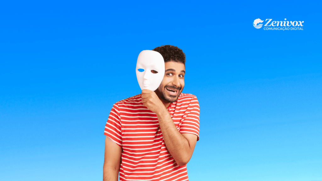 Homem sorrindo segurando uma máscara ao lado do rosto, simbolizando a síndrome do impostor e a diferença entre aparência e identidade real