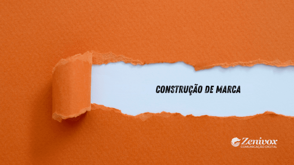 Construção de Marca representada por papel laranja rasgado revelando a expressão “Construção de Marca”, simbolizando o processo estratégico de revelar e estruturar a identidade de uma marca.